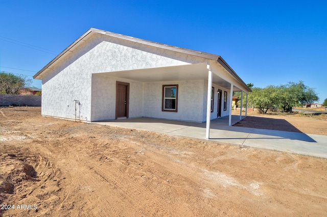 rear view of house with a patio and stucco siding