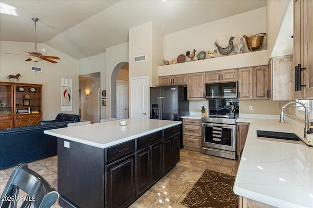 kitchen featuring visible vents, arched walkways, black refrigerator with ice dispenser, stainless steel range with electric cooktop, and a sink