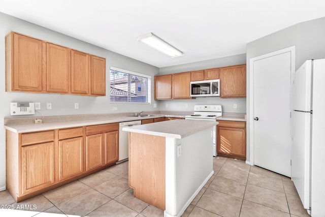 kitchen with white appliances, sink, light tile patterned floors, and a center island