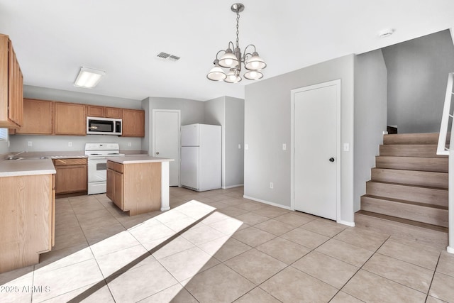 kitchen featuring white appliances, hanging light fixtures, a center island, an inviting chandelier, and sink