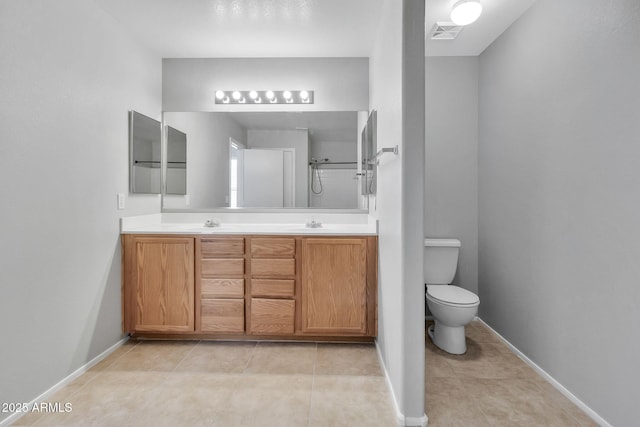 bathroom with toilet, a shower, tile patterned floors, and vanity