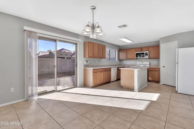 kitchen with stainless steel appliances, a notable chandelier, a kitchen island, decorative light fixtures, and light tile patterned flooring