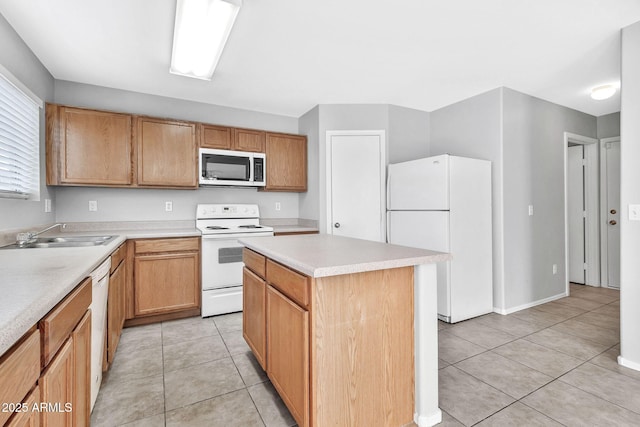 kitchen with white appliances, a kitchen island, light tile patterned floors, and sink