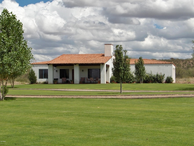 rear view of property with a lawn