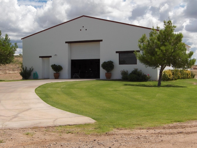 view of front of home featuring a front yard, an outbuilding, and a garage