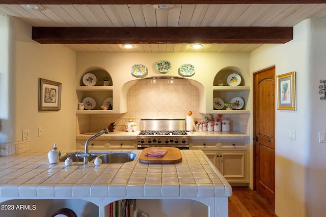 kitchen featuring sink, dark wood-type flooring, tile countertops, a breakfast bar, and high end range