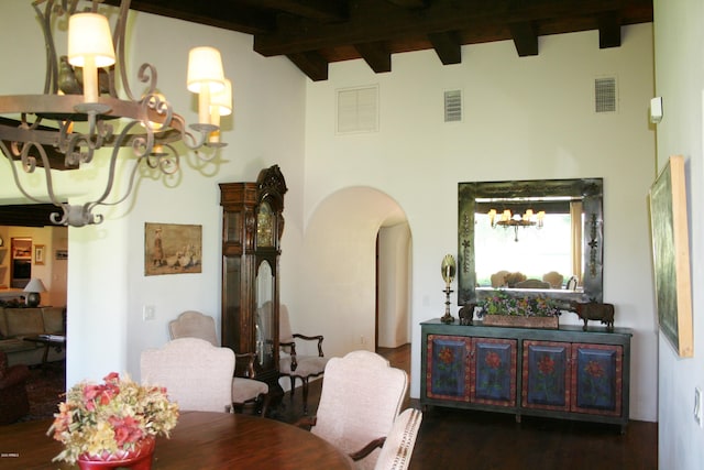 dining area featuring beamed ceiling, dark wood-type flooring, and a notable chandelier