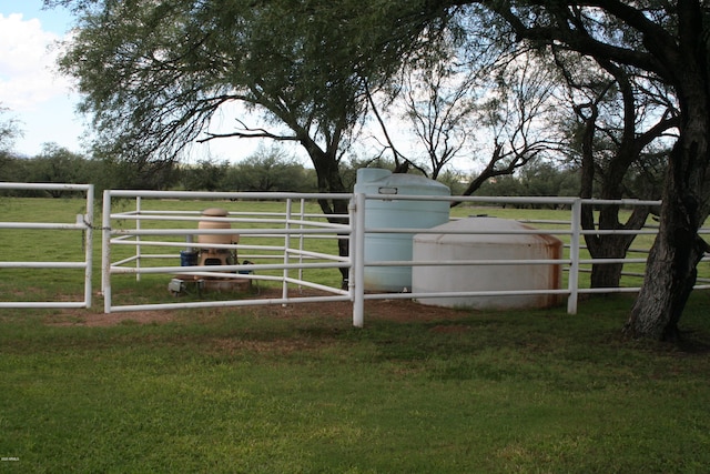 view of gate with a yard and a rural view