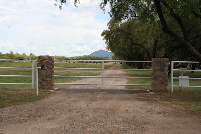 view of gate with a mountain view, a yard, and a rural view