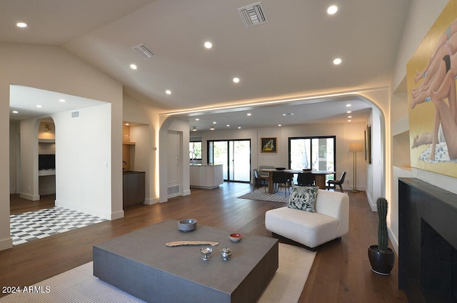 living room featuring wood-type flooring and vaulted ceiling