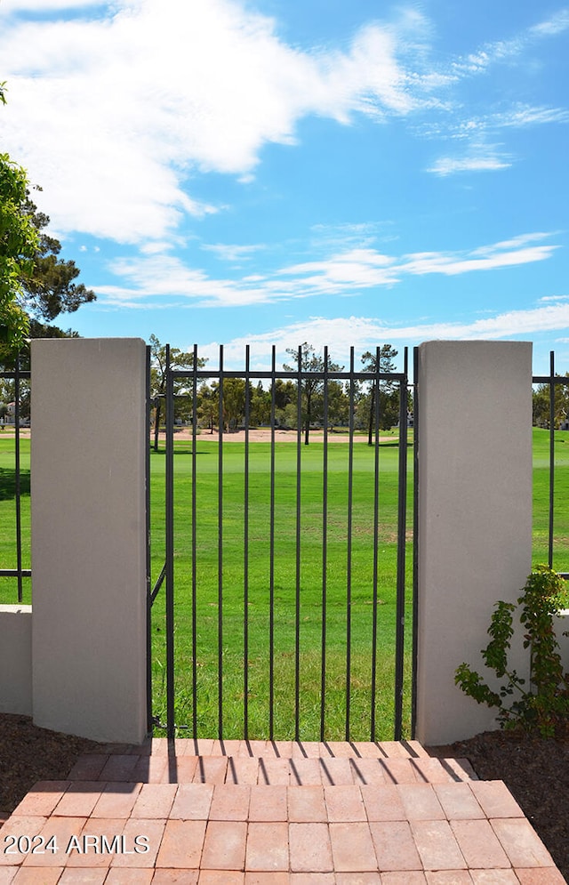 view of gate with a yard