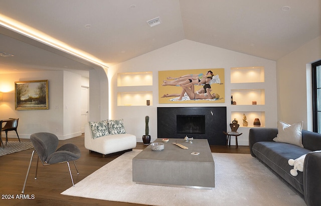 living room featuring built in features, dark wood-type flooring, and vaulted ceiling