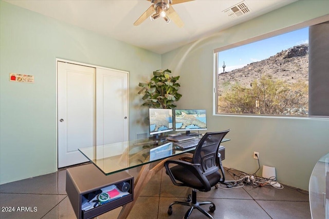 tiled home office featuring ceiling fan