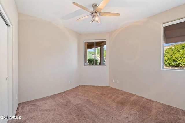 empty room featuring carpet floors and ceiling fan