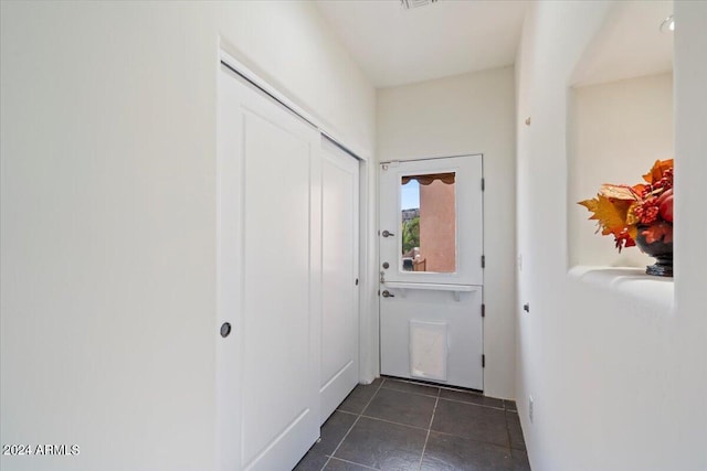 entryway with dark tile patterned floors