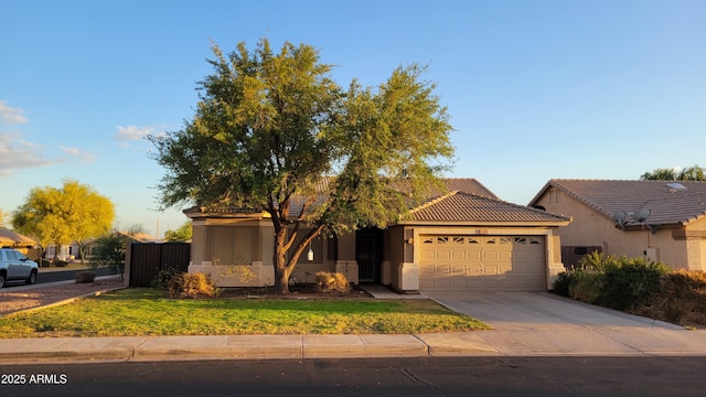 view of front facade with a front yard, a tiled roof, a garage, concrete driveway, and stucco siding