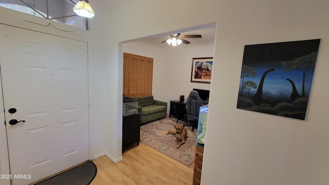 entrance foyer featuring light wood-type flooring, ceiling fan, crown molding, and baseboards
