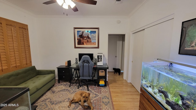 home office featuring crown molding, a ceiling fan, and wood finished floors