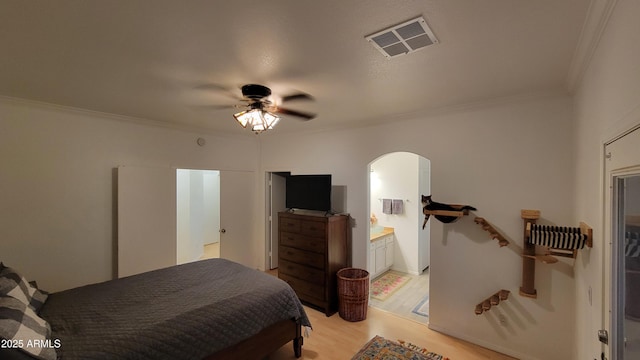 bedroom featuring crown molding, ceiling fan, light wood-style flooring, arched walkways, and visible vents