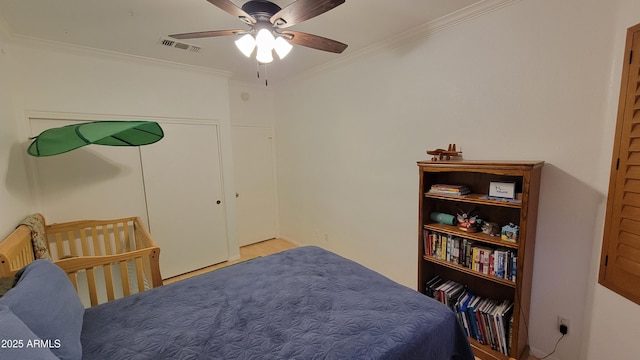 bedroom featuring ornamental molding, visible vents, ceiling fan, and wood finished floors