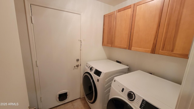 washroom featuring independent washer and dryer, light tile patterned floors, and cabinet space