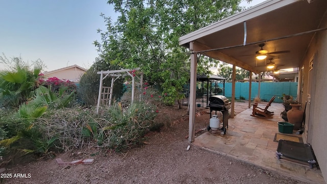 view of yard with a patio, a fenced backyard, and ceiling fan
