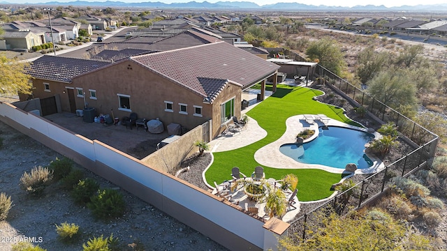 view of swimming pool featuring a mountain view, a lawn, and a patio