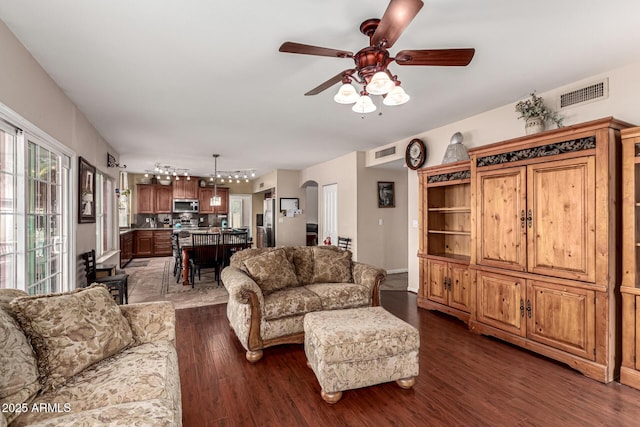 living area with dark wood-style floors, visible vents, track lighting, and a ceiling fan