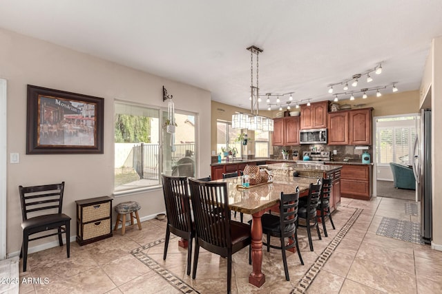 dining space featuring light tile patterned flooring and baseboards