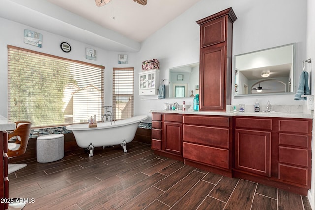 bathroom with a soaking tub, wood tiled floor, vaulted ceiling, and ceiling fan