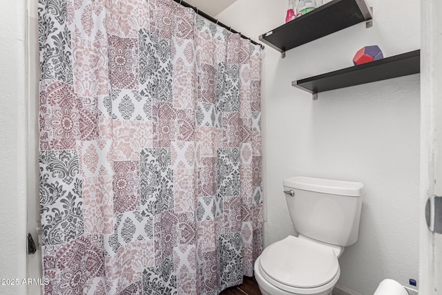 bathroom with a shower with curtain and toilet