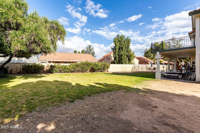 view of yard featuring a fenced backyard, a balcony, and a patio