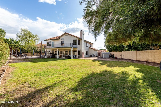 back of house with a fenced backyard, a chimney, a yard, and a patio area