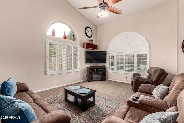 carpeted living area with a wealth of natural light, high vaulted ceiling, ceiling fan, and baseboards