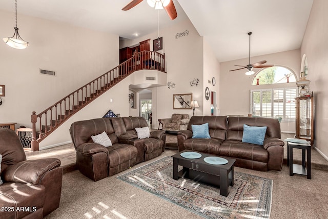 carpeted living room with plenty of natural light, stairs, visible vents, and a ceiling fan