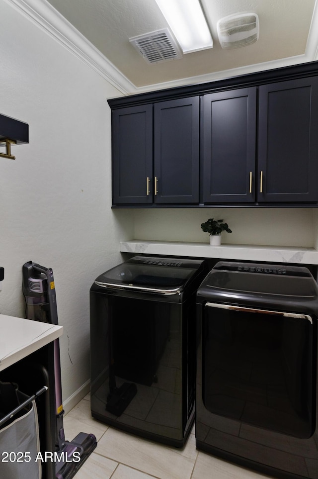 laundry room with ornamental molding, washer and clothes dryer, cabinet space, and visible vents