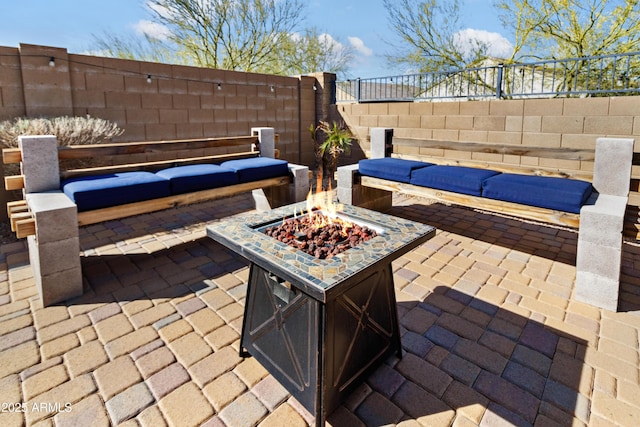 view of patio with an outdoor living space with a fire pit and fence