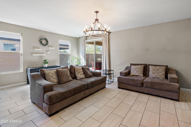 living room featuring an inviting chandelier and baseboards