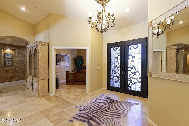 entryway with french doors, an inviting chandelier, and light tile floors