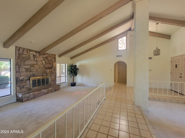 unfurnished living room with high vaulted ceiling, light tile patterned floors, beamed ceiling, and a fireplace