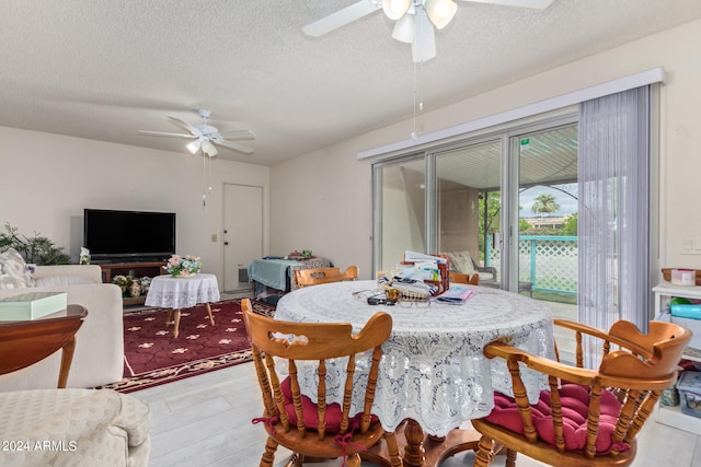 dining area with ceiling fan, a textured ceiling, and wood-type flooring