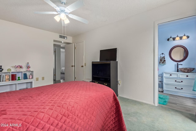 carpeted bedroom with ceiling fan and a textured ceiling