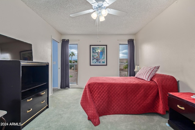 carpeted bedroom with ceiling fan and a textured ceiling