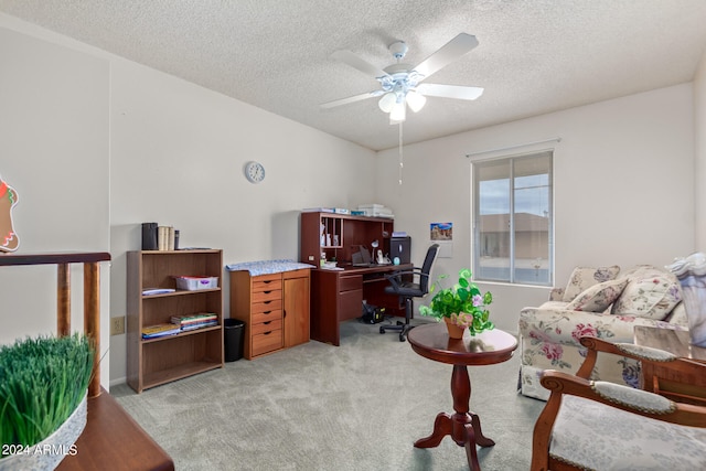 home office featuring ceiling fan, light colored carpet, and a textured ceiling