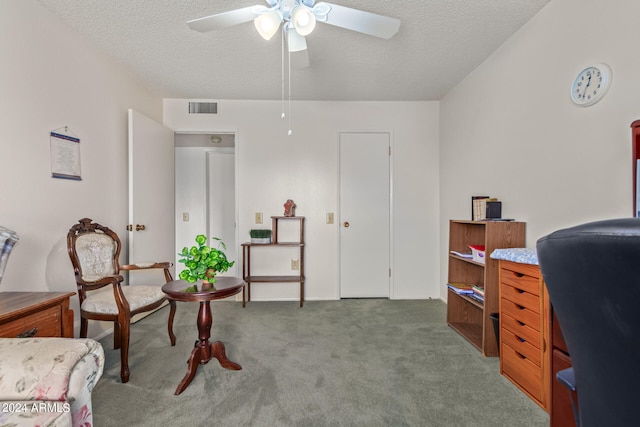 interior space featuring ceiling fan, a textured ceiling, and light carpet