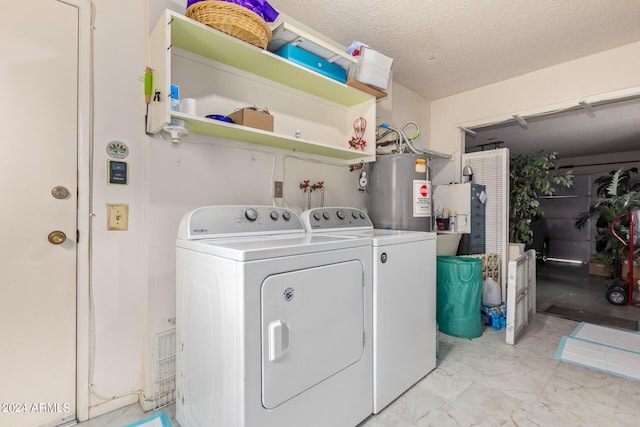 clothes washing area with gas water heater, a textured ceiling, and independent washer and dryer