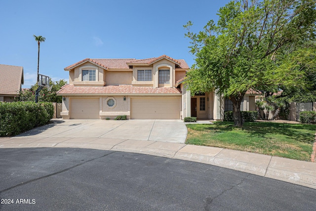 mediterranean / spanish house with a garage and a front lawn