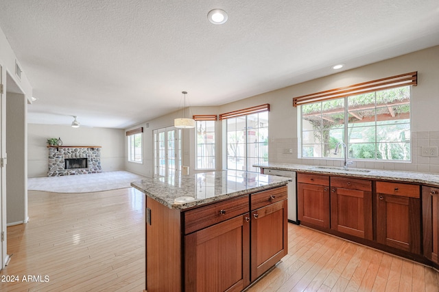 kitchen featuring dishwasher, decorative light fixtures, plenty of natural light, and sink