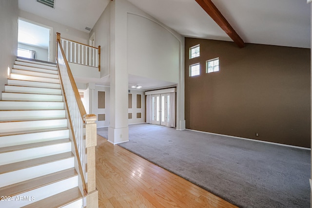 entrance foyer with high vaulted ceiling, plenty of natural light, beamed ceiling, and light hardwood / wood-style flooring