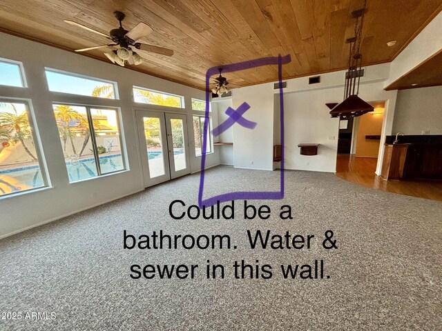 empty room featuring light carpet, crown molding, and french doors